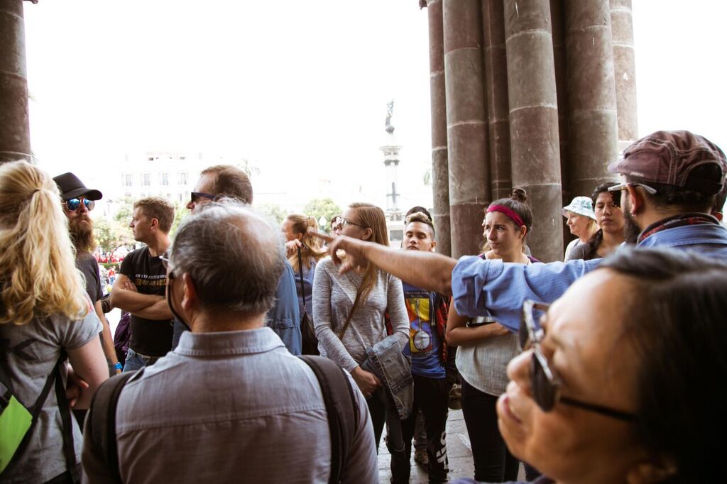A guide talking with tourists about a church.